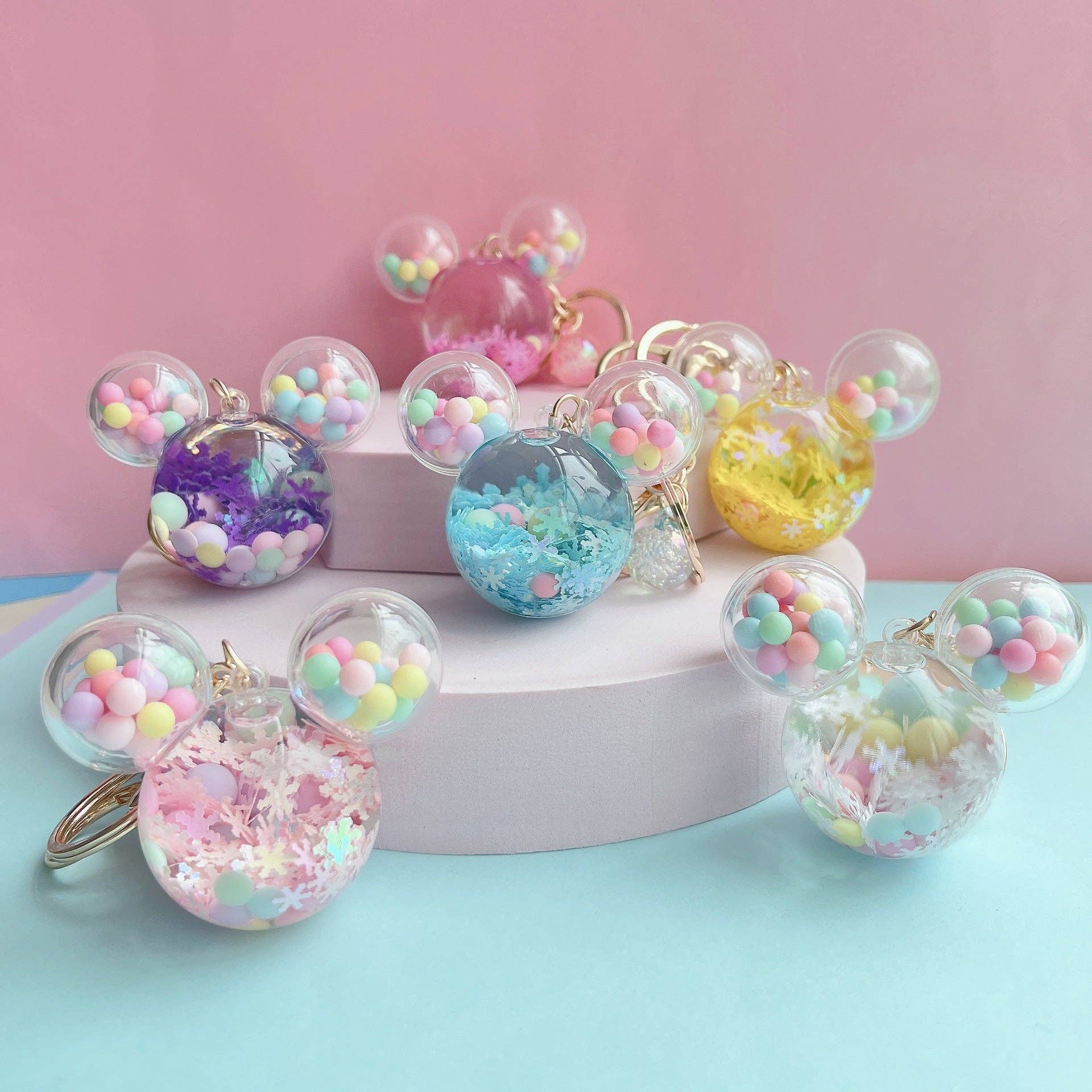 Colorful keychains with pastel beads on a pink and blue background