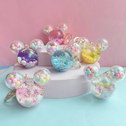 Colorful keychains with pastel beads on a pink and blue background
