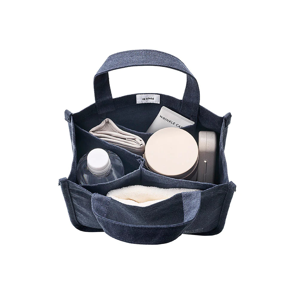 Blue denim caddy with various items on a white background