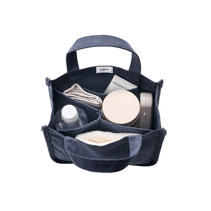 Blue denim caddy with various items on a white background