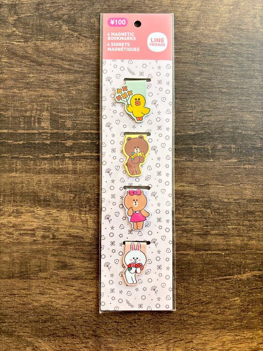 Pack of magnetic clips with cartoon characters on a wooden surface