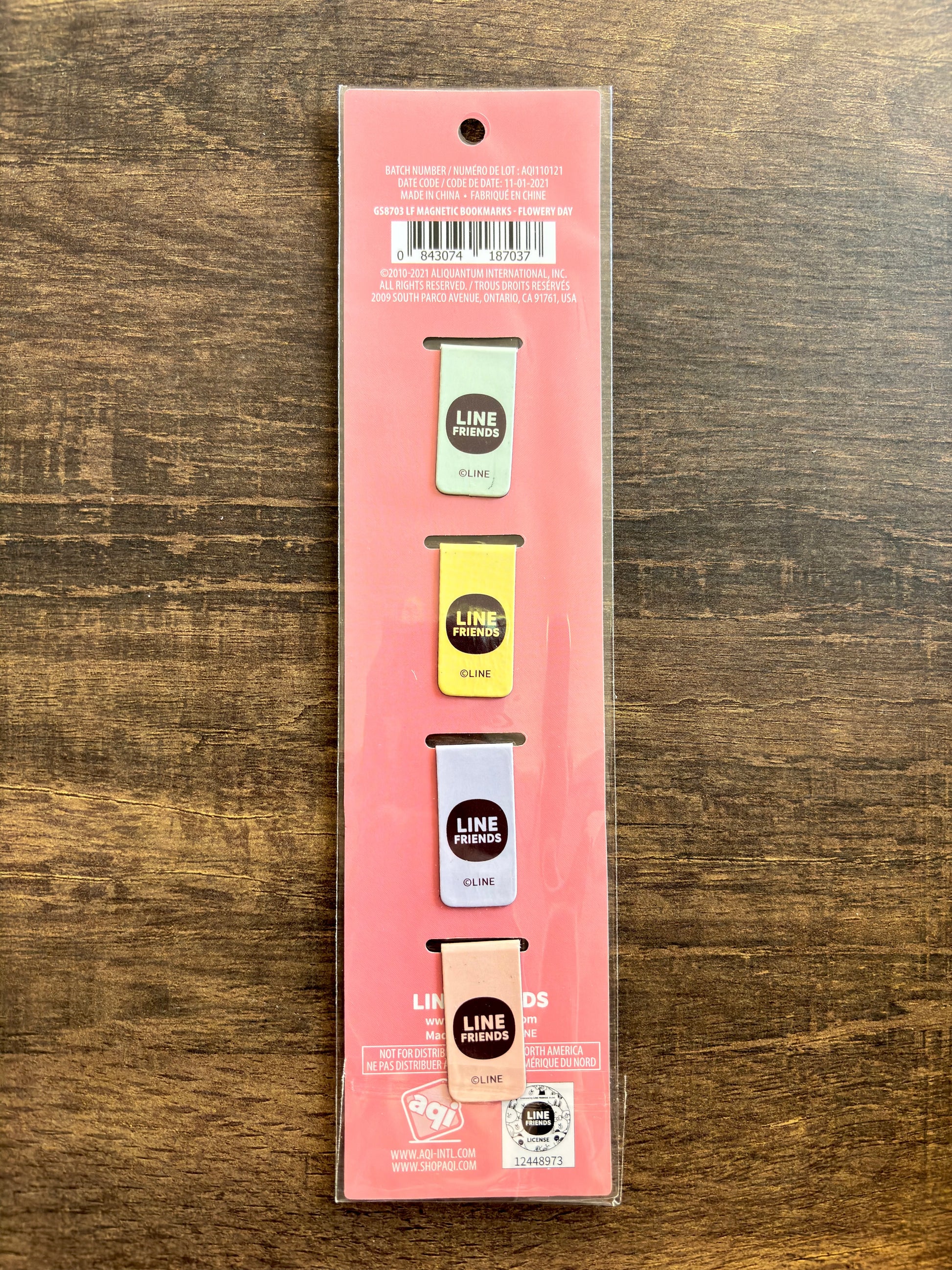 back of packaged product with the backs of 4 small magnetic clips on a wooden surface