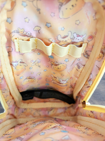 Close-up of a pencil/pen bag with cartoon designs and a yellow strap.