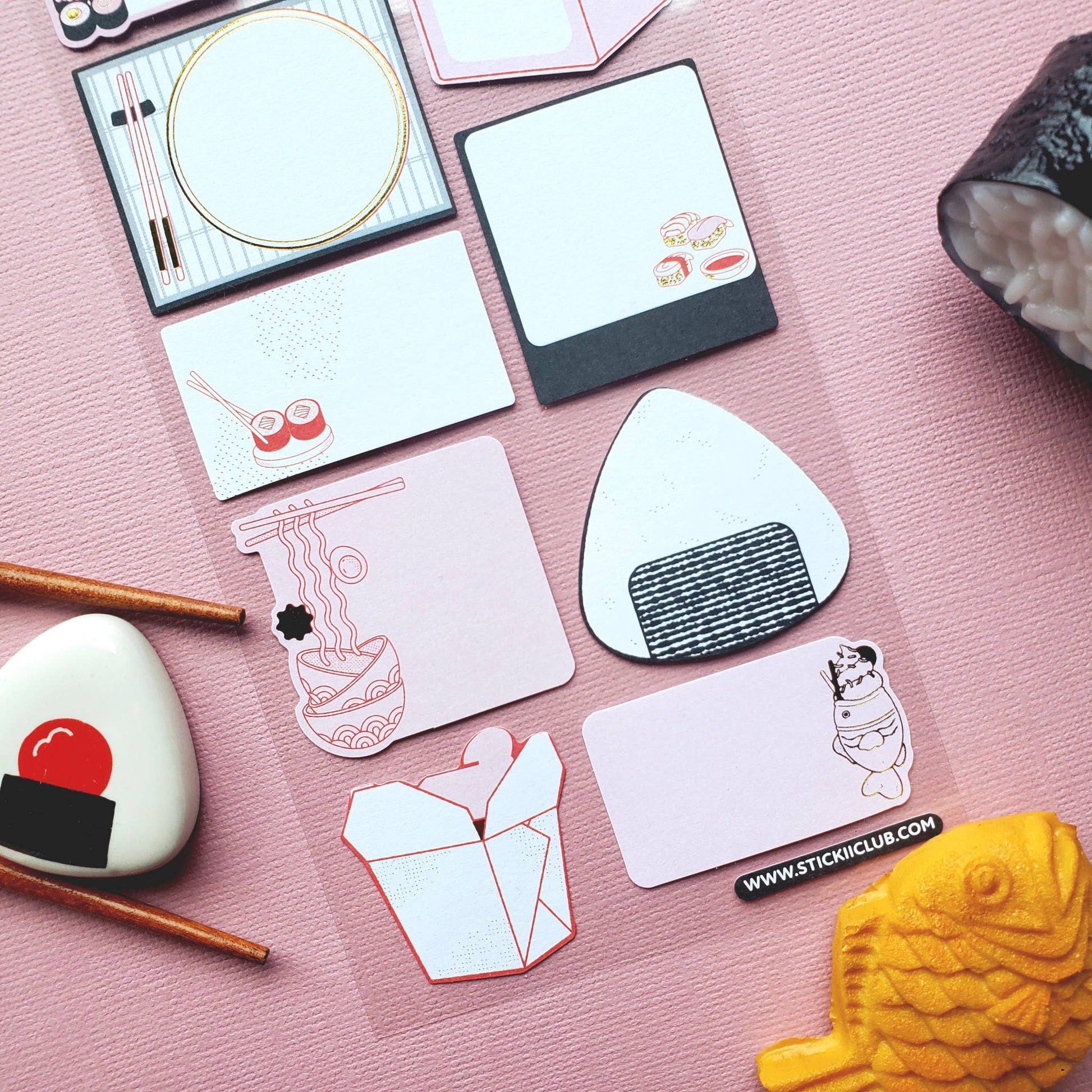 Collection of decorative Japanese food stickers on a pink surface with a sushi-themed design.