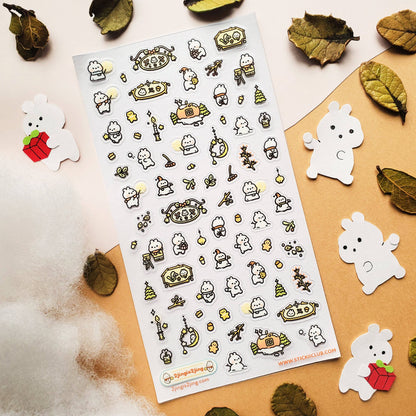 Sheet of decorative winter holiday stickers with cartoon characters on a beige surface with leaves.