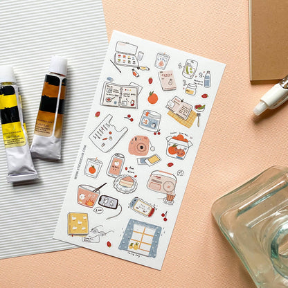 Sheet of illustrated stickers on a pink surface with art supplies.