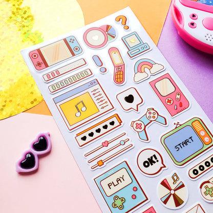 Sheet of colorful retro-themed stickers on a pink surface with sunglasses and a toy.