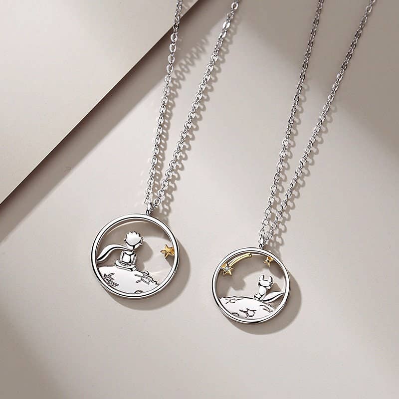 Two silver necklaces with circular pendants on a neutral background