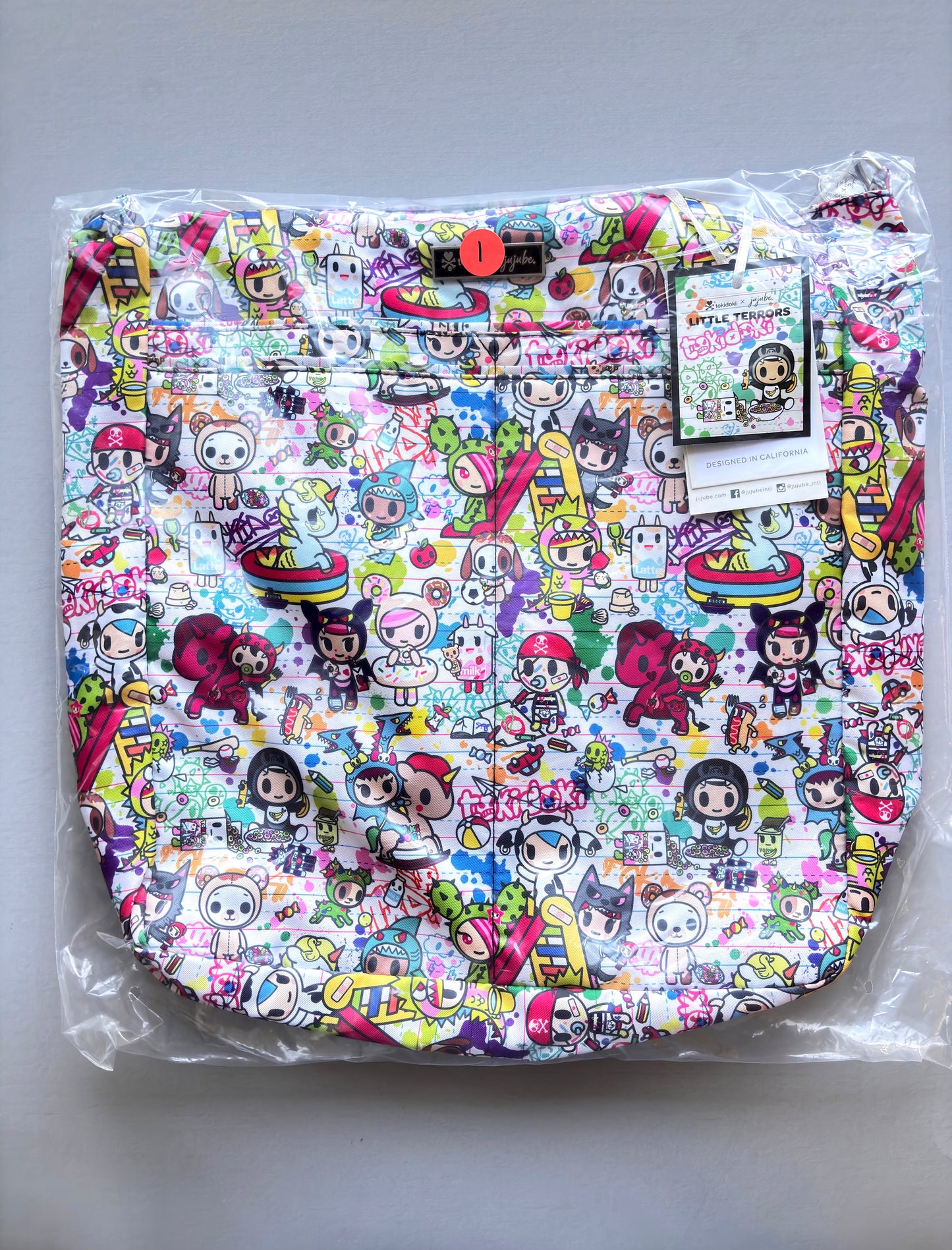Colorful cartoon-patterned product in clear packaging on a gray background