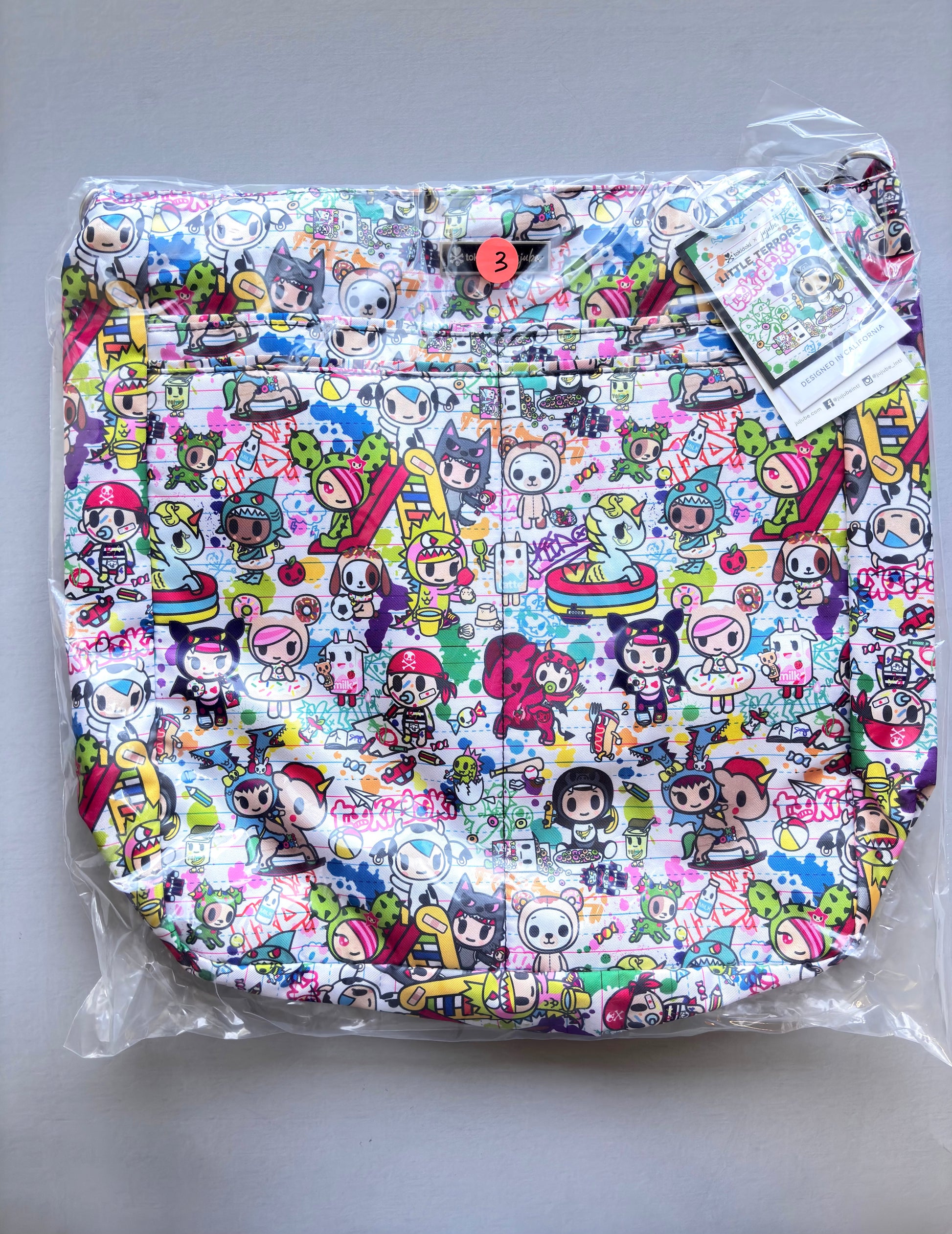 Colorful patterned bag with cartoon characters on a gray background