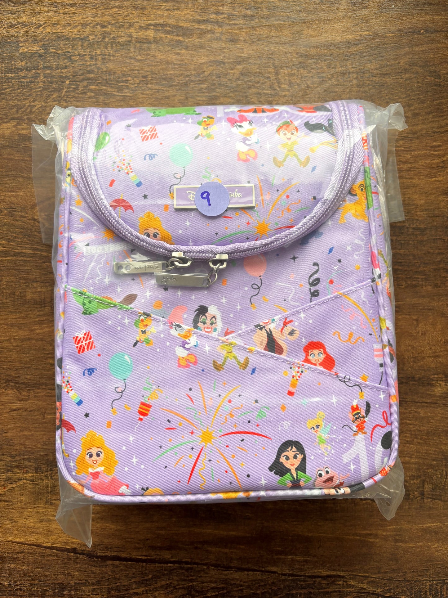 Disney insulated lunch bag with colorful character print on a wooden surface