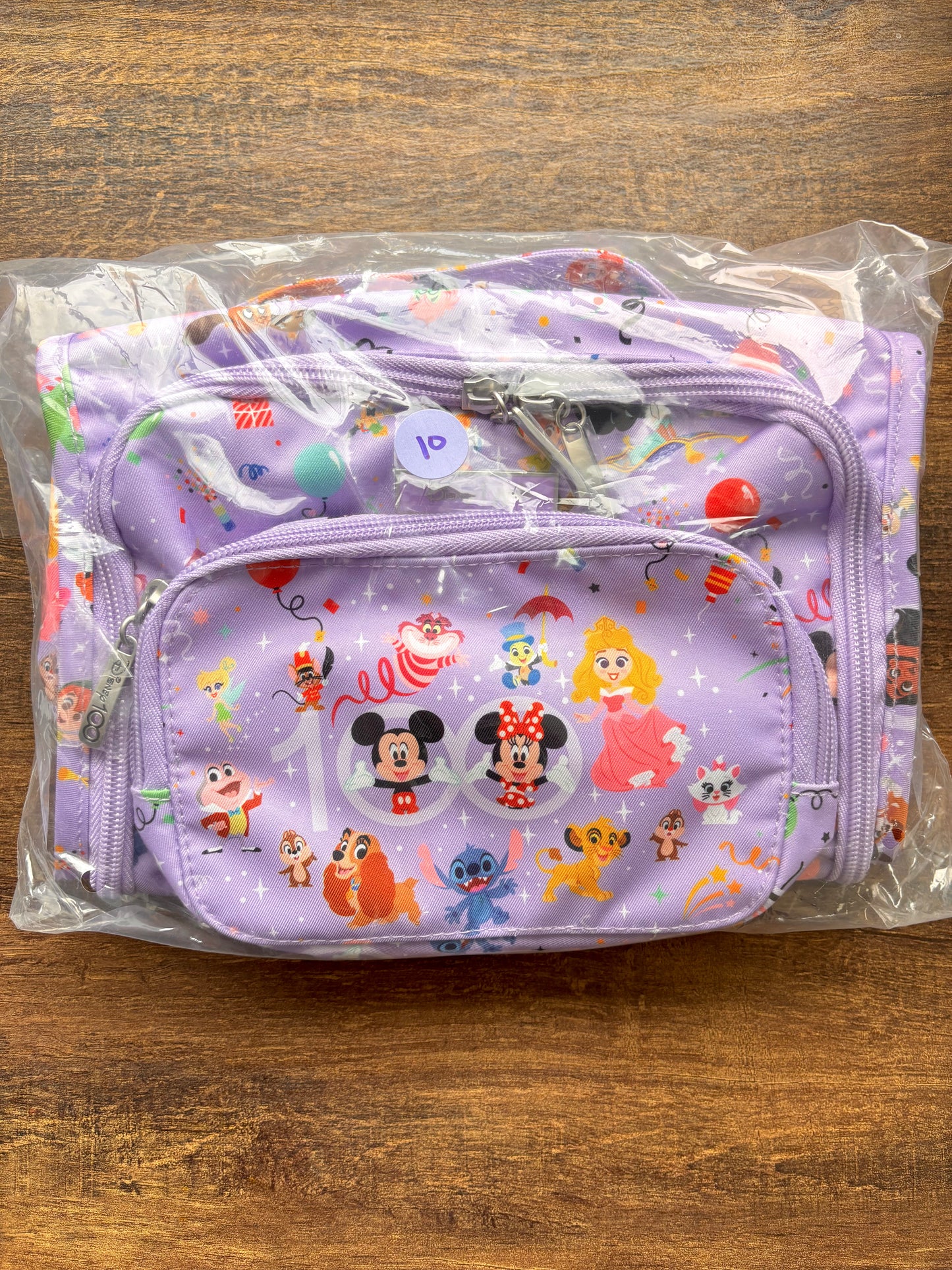 Packaged purple pouch with cartoon character designs on a wooden surface