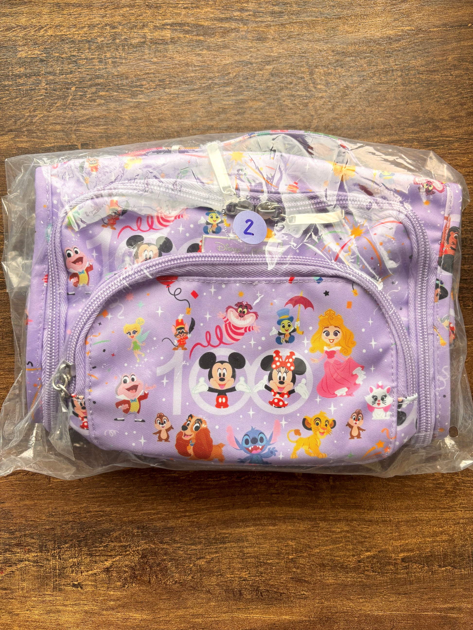 Disney-themed pouch in clear plastic packaging on a wooden surface
