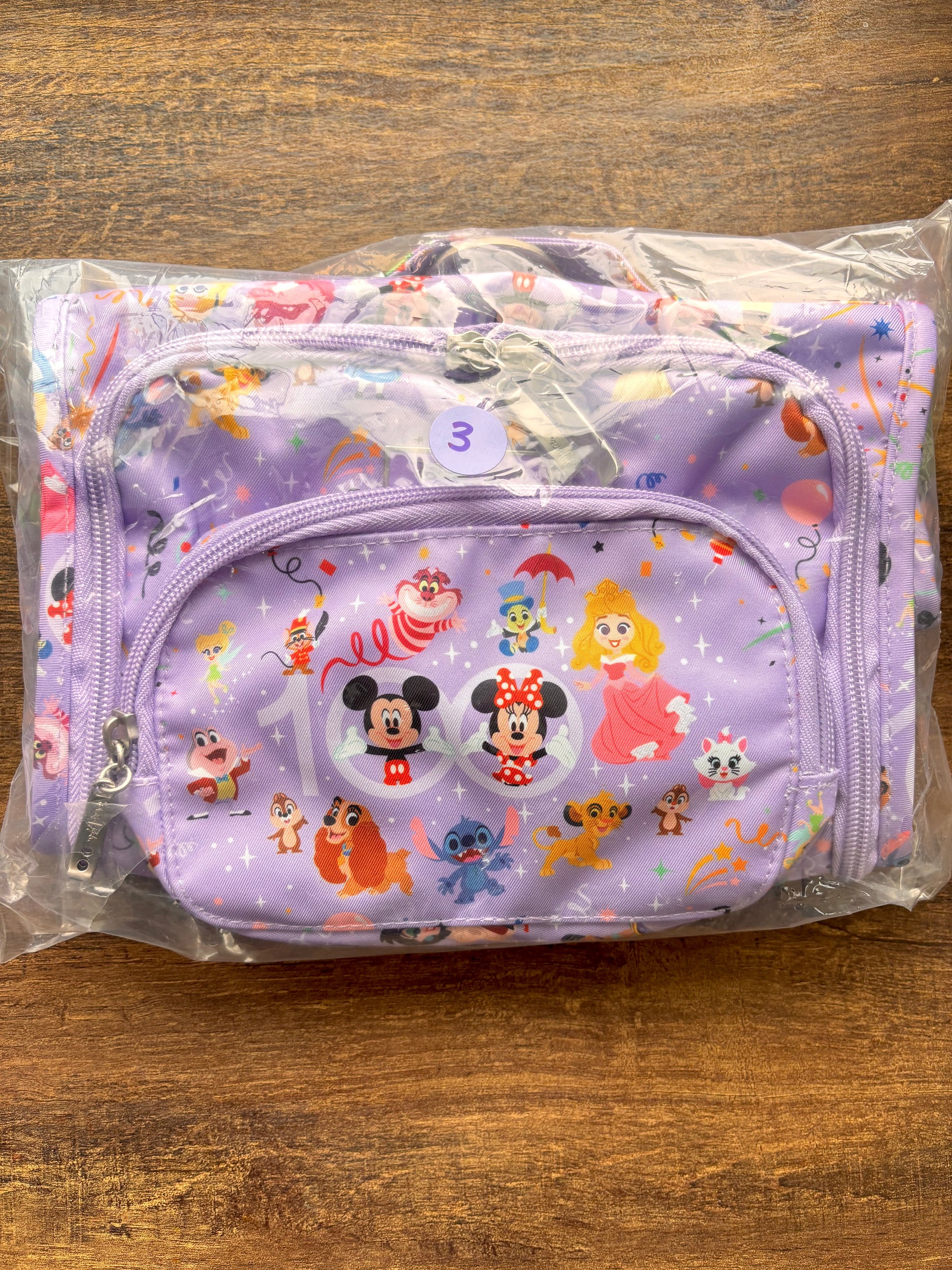 Disney-themed pouch with cartoon characters on a wooden surface