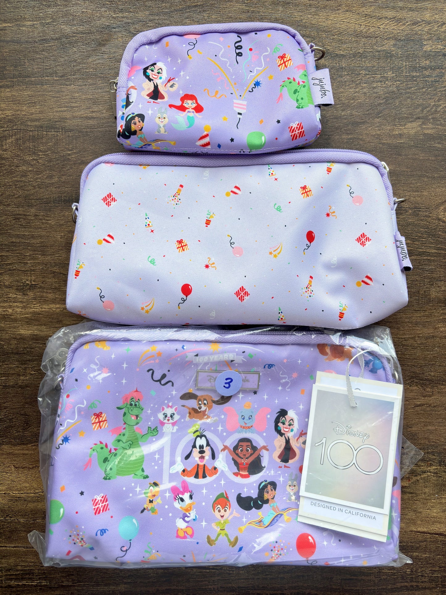 Set of purple pouches with DISNEY cartoon character prints on a wooden surface