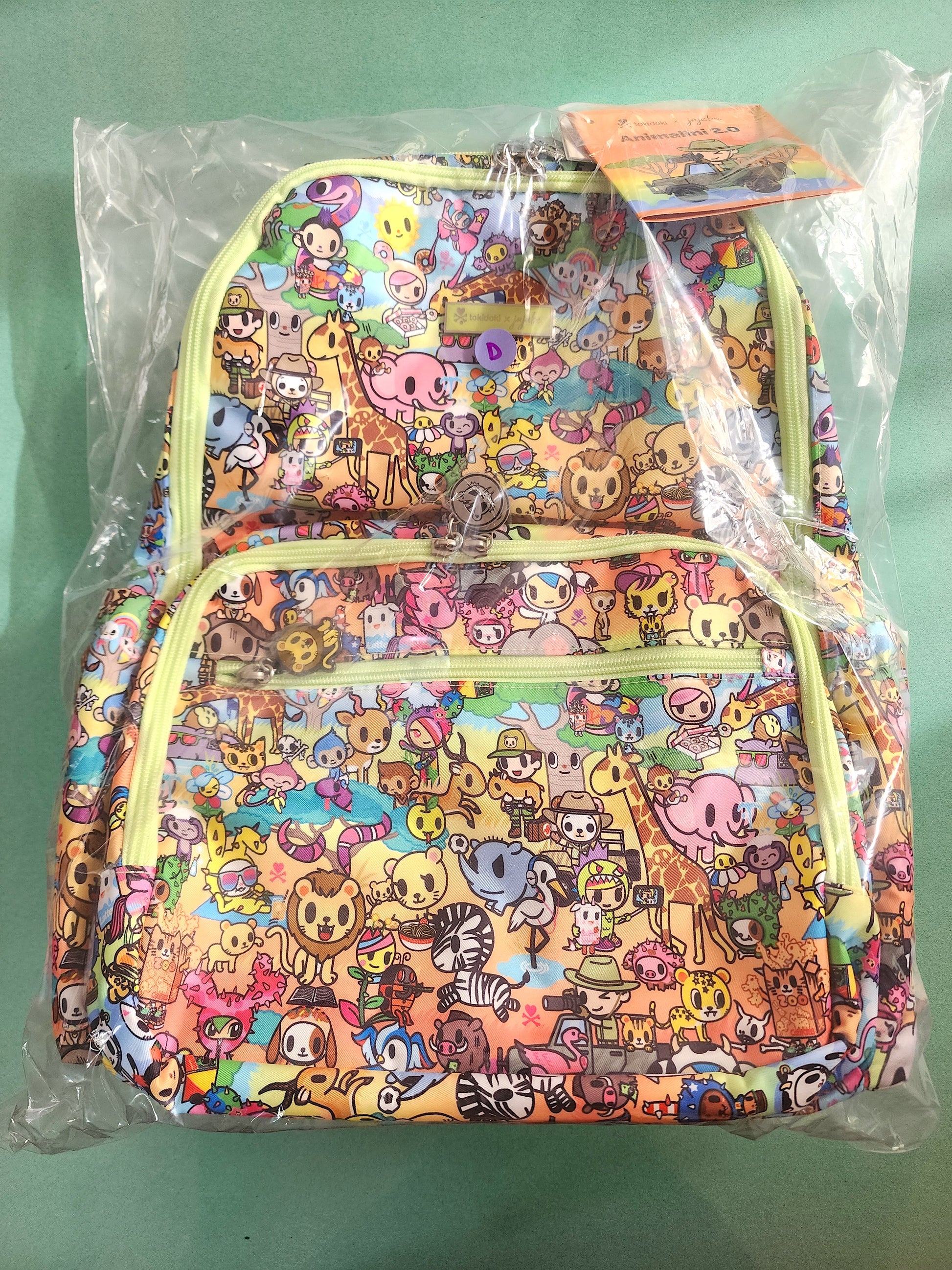 Colorful backpack with animal pattern in clear packaging on a green background