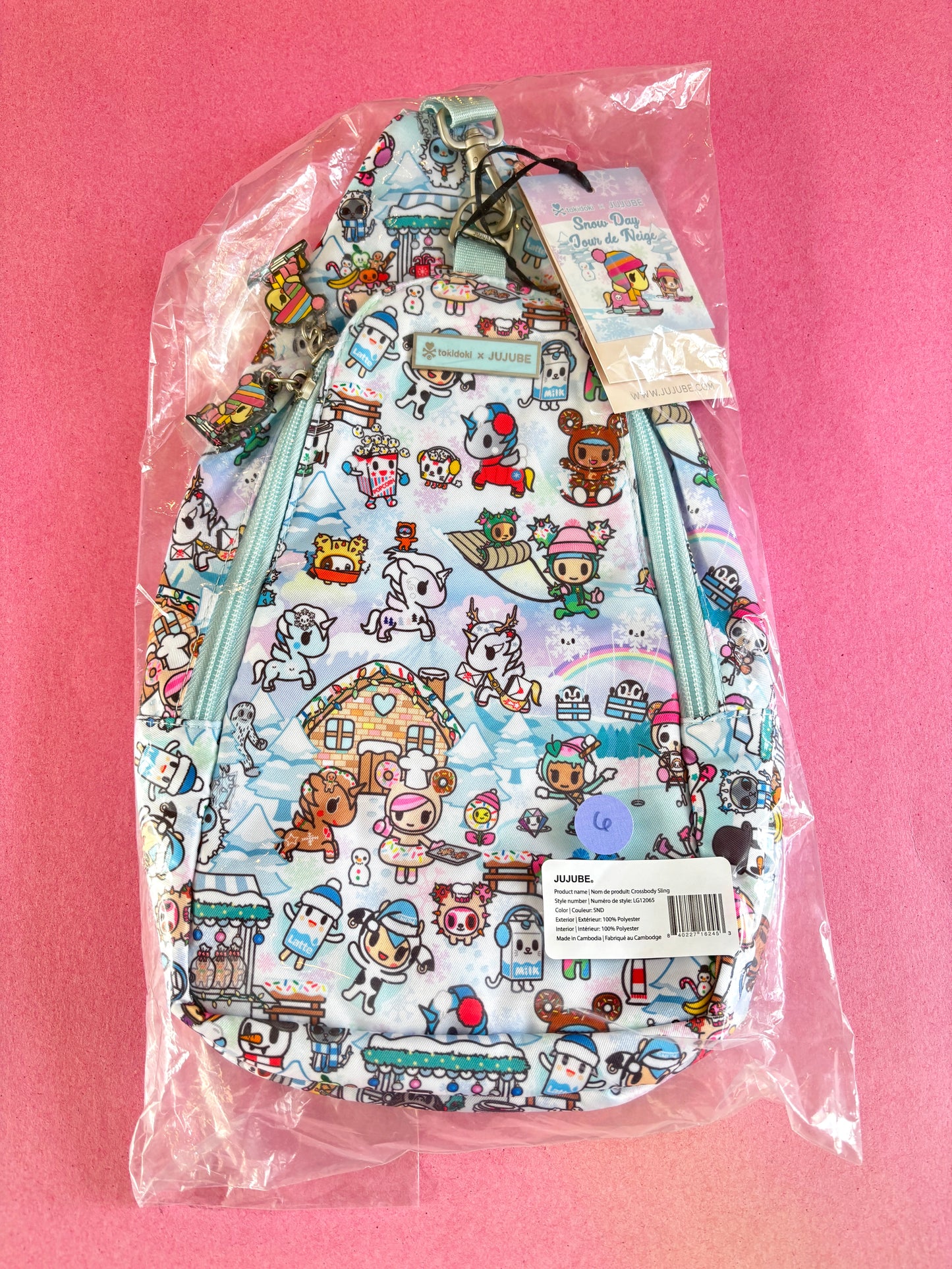 Cute backpack with cartoon character pattern in clear packaging on a pink background