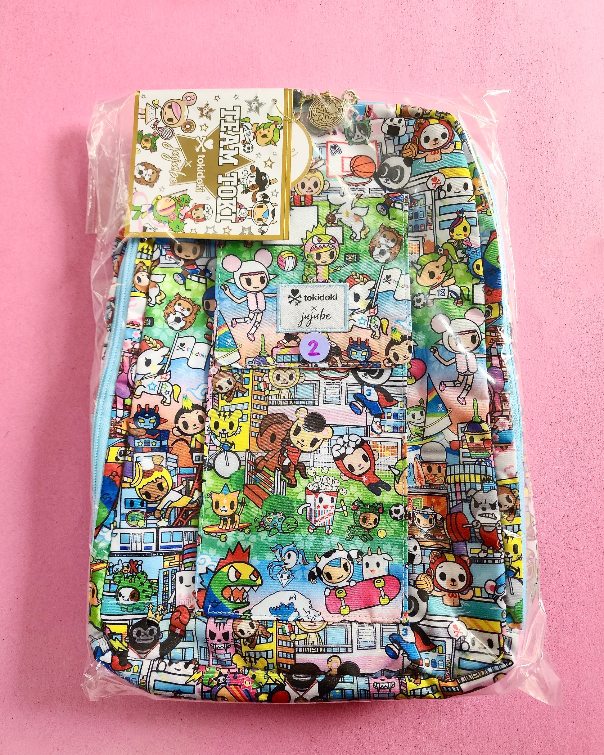 Colorful backpack with cartoon character pattern on a pink background