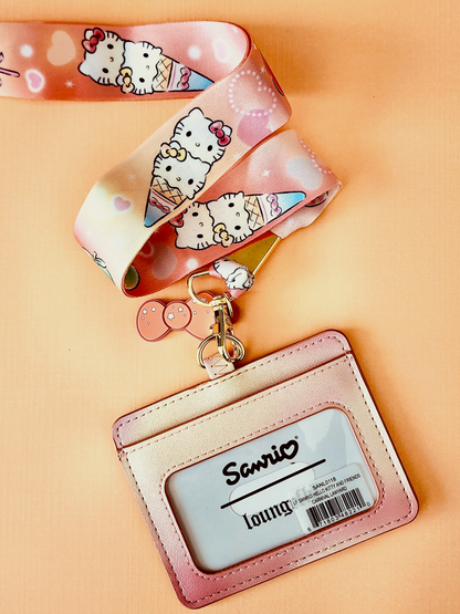 Pink lanyard with Sanrio cartoon character design and matching cardholder on a beige background