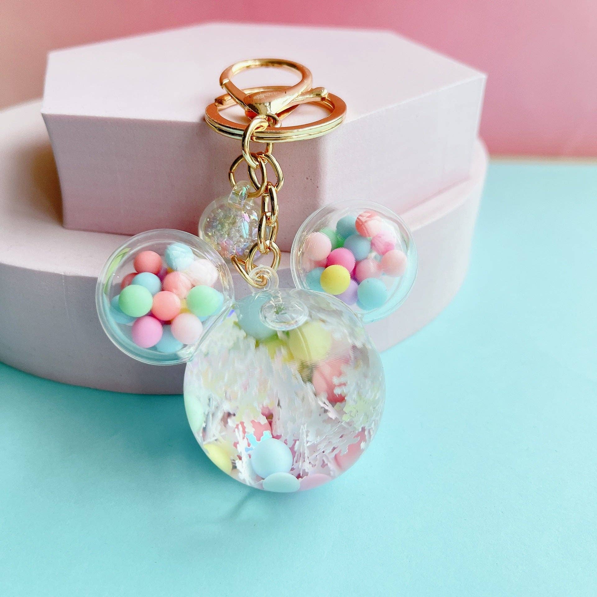 Mouse Head Shaped Keychain with colorful beads and gold accents on a light blue background