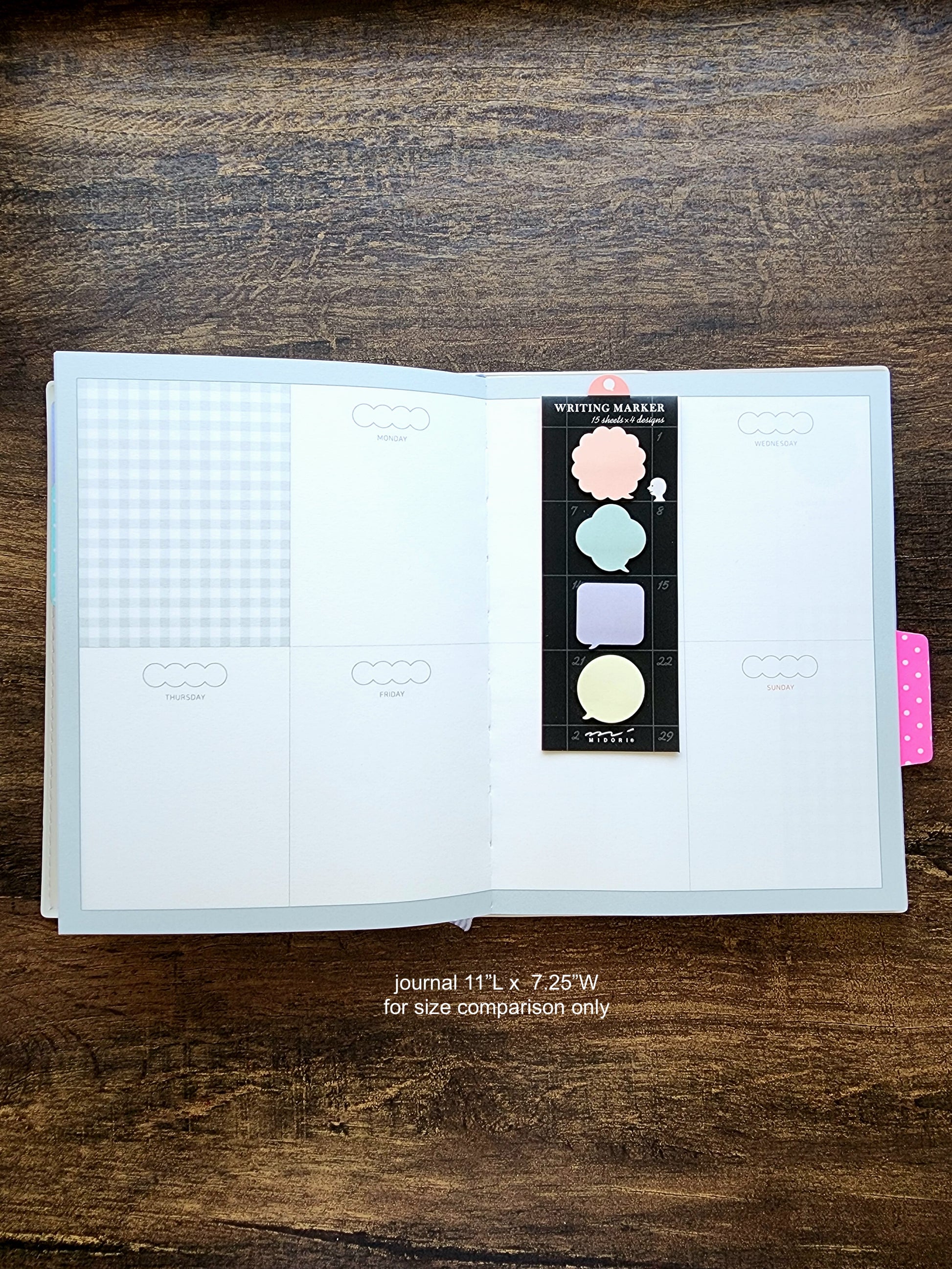 Open planner notebook with a sticky note package on a wooden surface