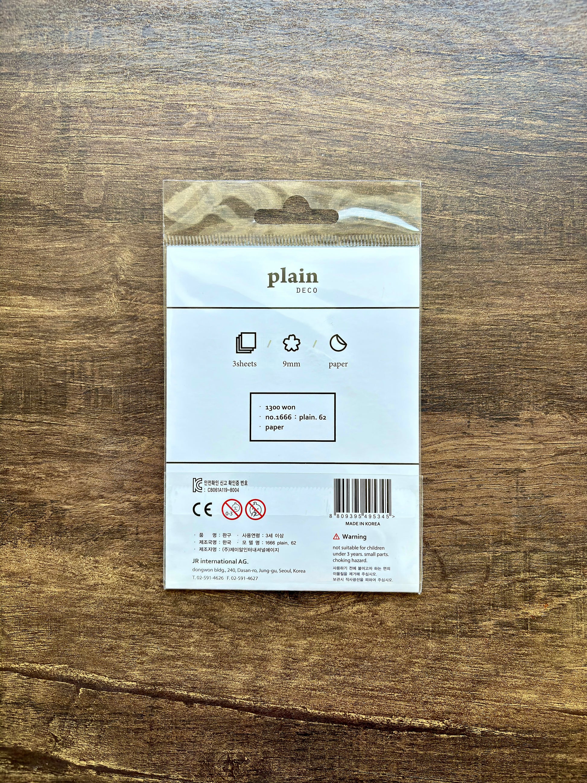 Product packaging with 'plain' branding on a wooden surface