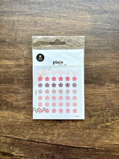 Pack of plain stickers with floral designs on a wooden surface