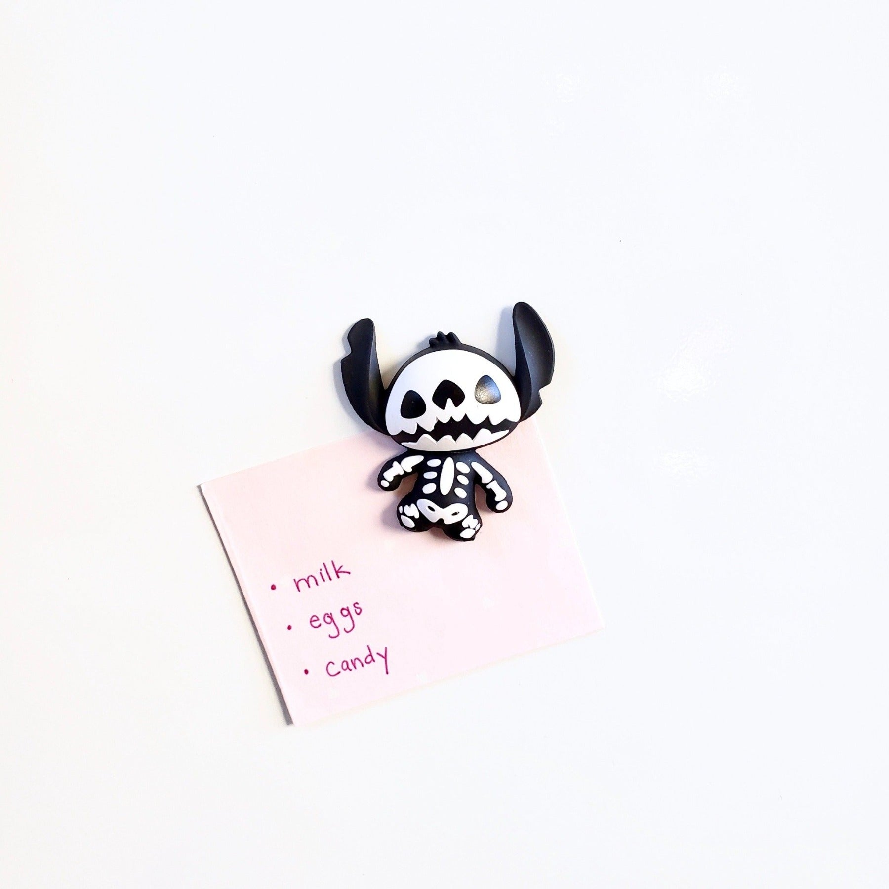 shopping list hung on magnetic surface with Disney Stitch Skeleton 3D vinyl figure magnet