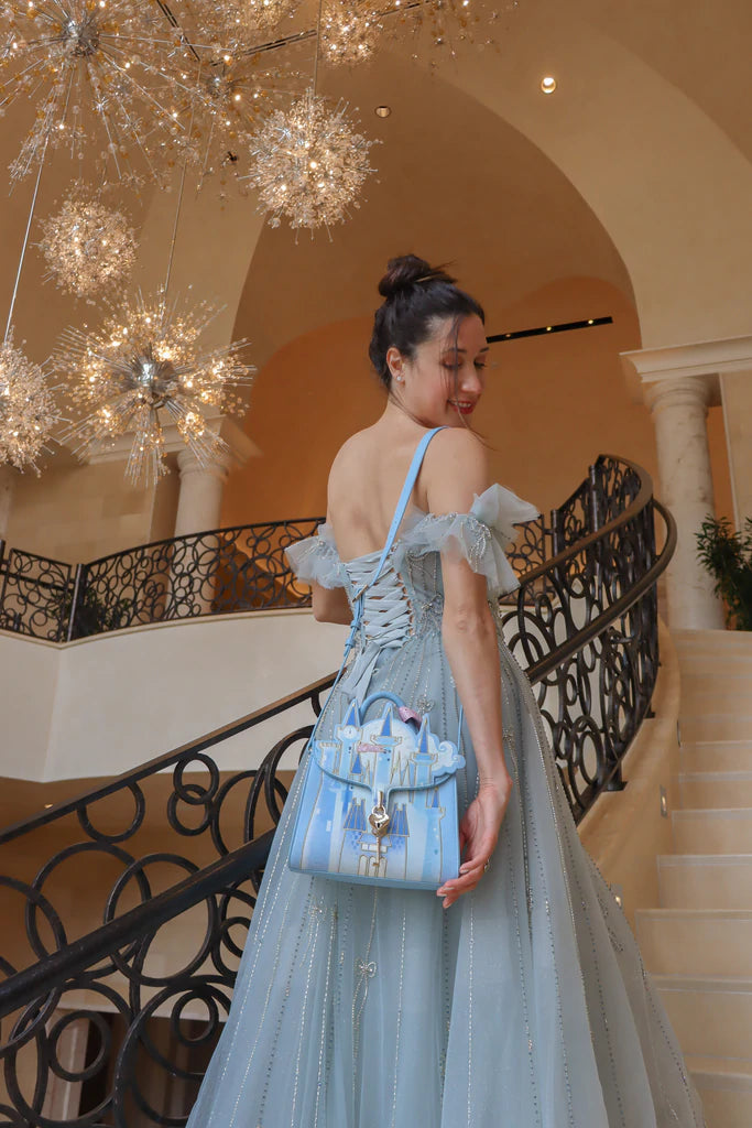 Danielle Nicole Cinderella's Royal Castle crossbody on female dressed in light blue ballgown on a grand staircase