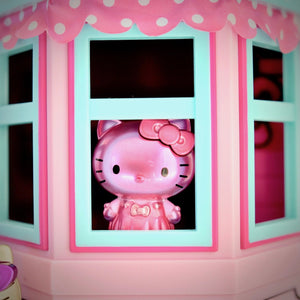 unboxed all-pink Hello Kitty Metalfigs inside window of Hello Kitty dollhouse