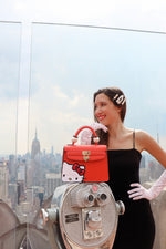Danielle Nicole Hello Kitty Peek-A-Boo red satchel with girl in black dress city skyline