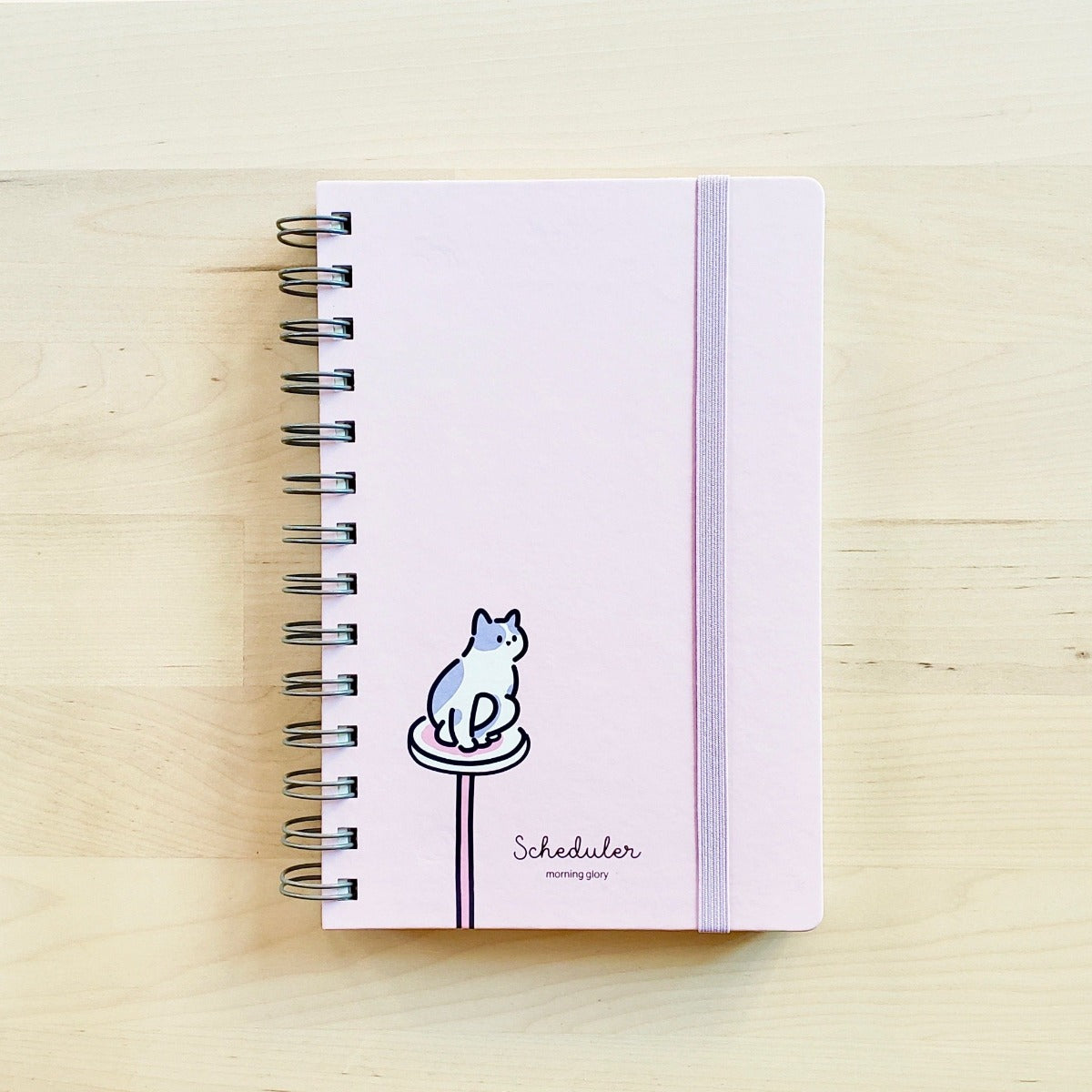 front cover of light pink morning glory scheduler with cat perched on cat tower